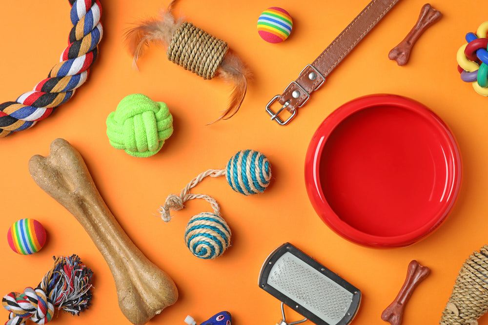 Full range of products for dogs and cats, including colourful toys, a chew bone, collar, red bowl and grooming brush